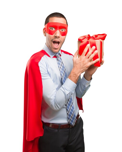 Happy super businessman with a gift