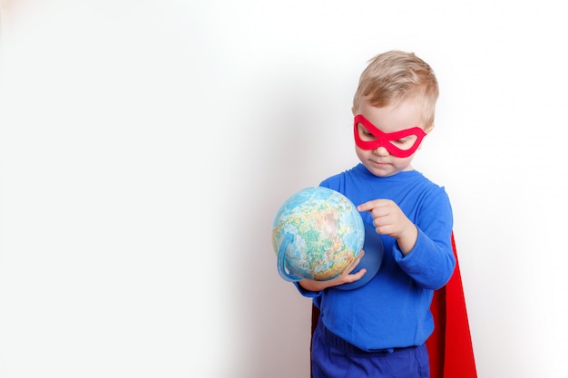 Счастливый супер герой мальчик держит глобус в руке, концепция спасения мира