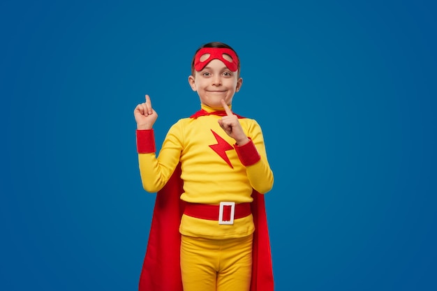 Happy superhero kid pointing up