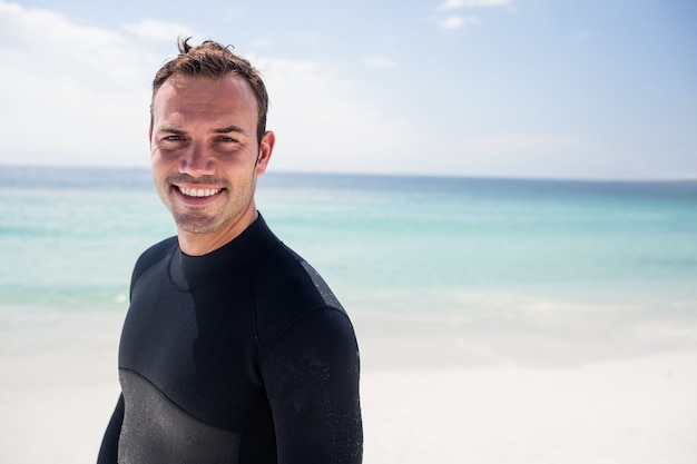 Happy surfer standing on beach