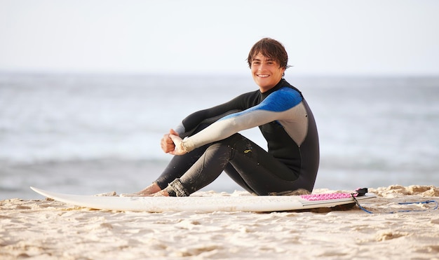 happy surfing and portrait of a man at the beach for water sports happiness and holiday in bali smile training and surfer with a board for exercise ocean break and activity on a vacation