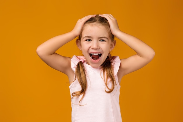 Happy surprised beautiful little child girl in dress looking to camera
