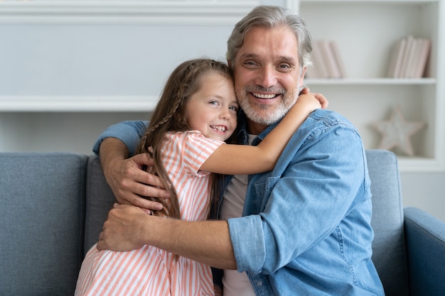 Happy sweet girl hugging her father at home.