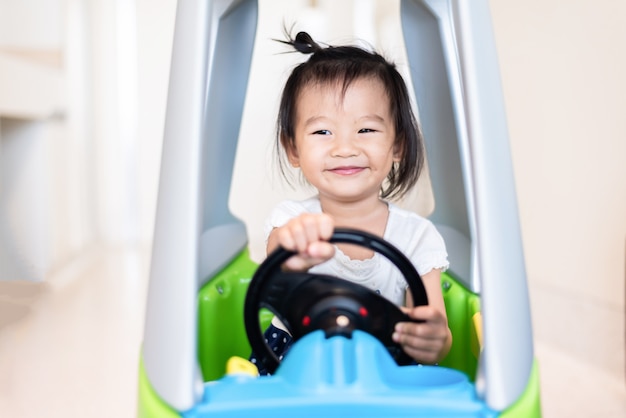 Happy Sweet Little Aziatische meisje rijden op kleine auto met glimlachen