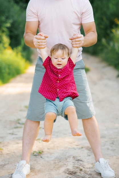 Happy and sweet moments of a summer walk in the park of a father and a little son