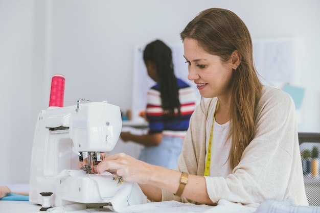 Happy Tailor woman Fashion Stylish Clothing Designer work with sewing machine at own business studio