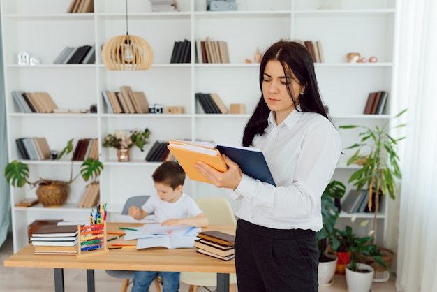 Happy teacher giving smiling girl private lessons after school