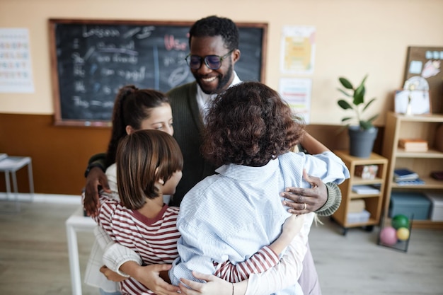 happy teacher and students hugging