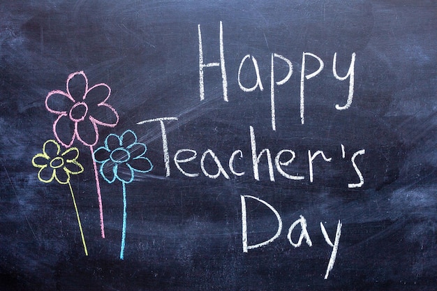 Happy teachers day scritto in lavagna con gesso bianco