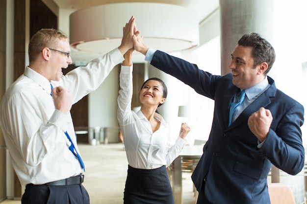 Happy team giving hi-five after successful work