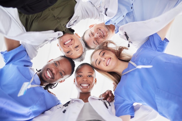 Photo happy teamwork diversity and doctors in huddle of support help or medical collaboration portrait group of healthcare workers in circle with heads together smile face and happy hospital management