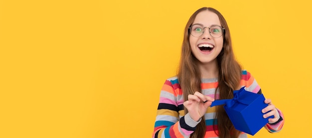 Happy teen girl in eyeglasses opening gift box for birthday Teenager girl with birthday gift horizontal poster