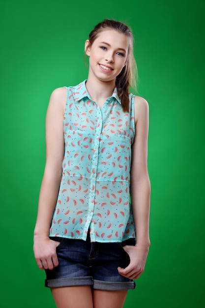 Happy teen girl half length portrait isolated on green background