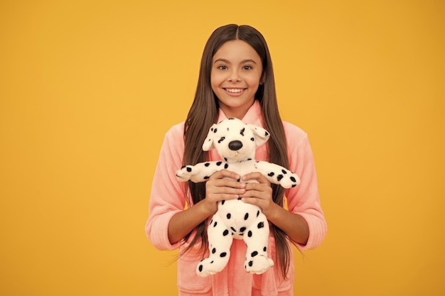 Happy teen girl in home terry bathrobe with toy smile