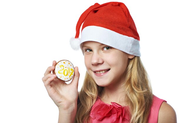 Photo happy teen girl in red cap with christmas cookie isolated