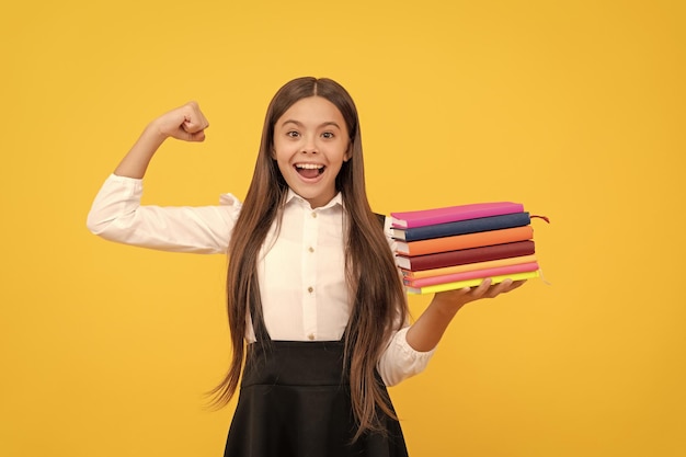 Happy teen girl in school uniform hold book stack happiness