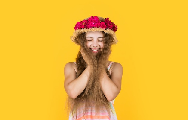 Happy teen girl in straw hat with rose flowers summer