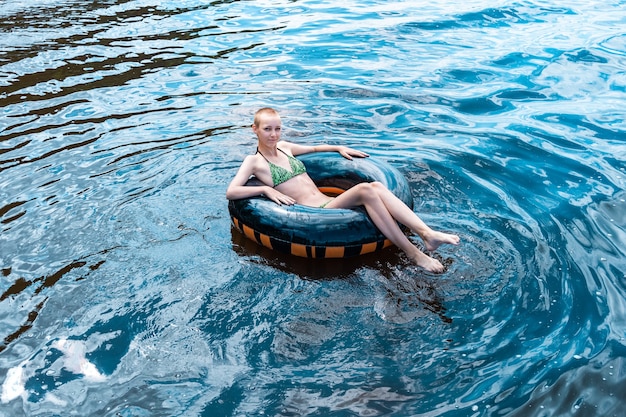 Happy teen girl swimming using a swim tube