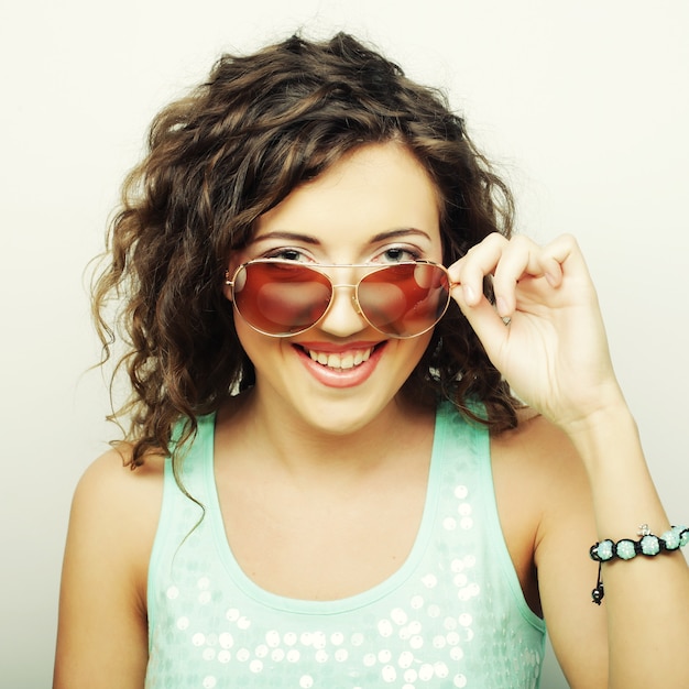 Happy teen girl with sunglasses over white background