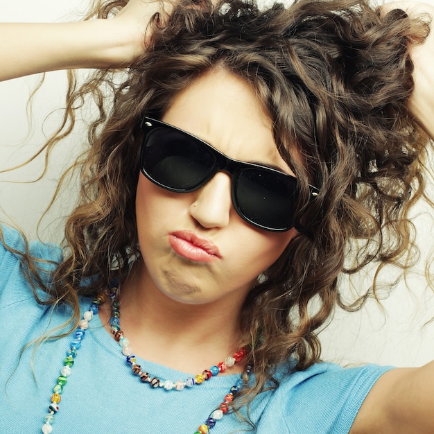 Happy teen girl with sunglasses over white background