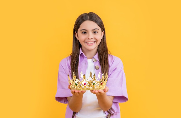 Photo happy teen girlish girl with crown isolated on yellow teen girlish girl with crown in studio