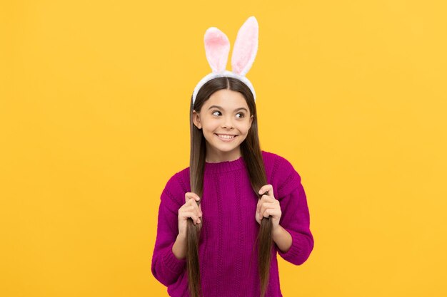 Happy teen kid in bunny ears having fun on easter holiday bunny hunt