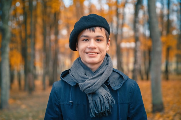 Happy teenage boy in the autumn sunny park