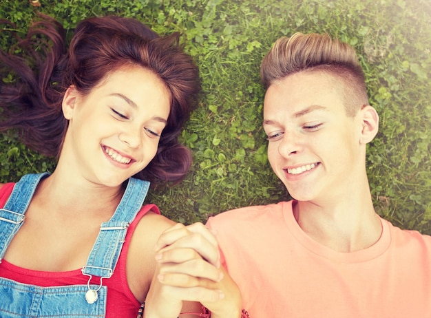 Foto coppia di adolescenti felici sdraiati sull'erba in estate