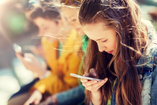 Foto amici adolescenti felici con smartphone all'aperto