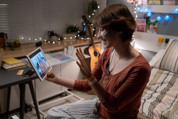 Photo happy teenage girl looking at her friends on tablet screen