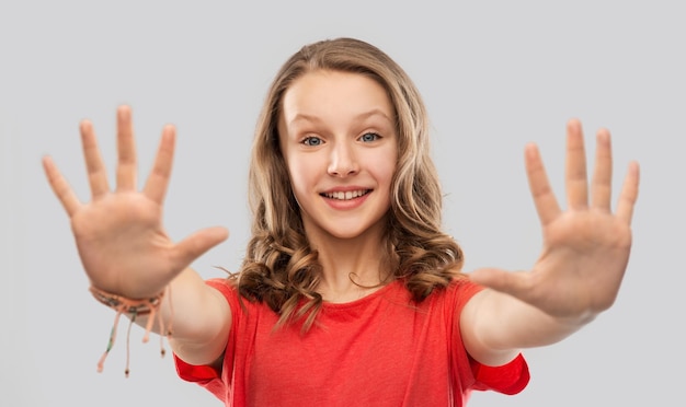 Foto ragazzina felice in maglietta rossa che dà un cinque