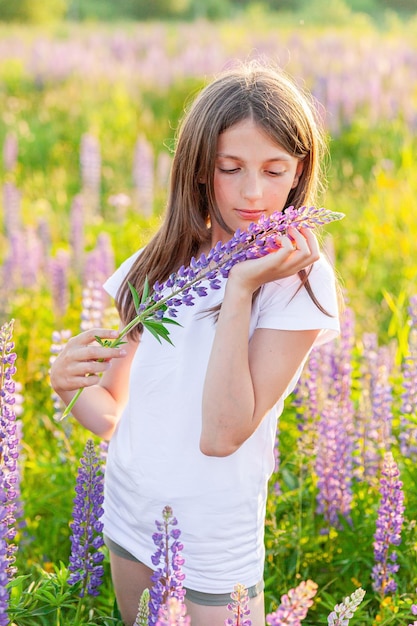 Happy teenage girl smiling outdoor beautiful young teen woman resting on summer field with blooming