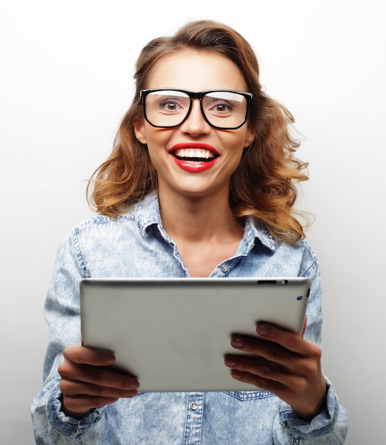 Happy teenage girl wearing glasses with tablet pc computer