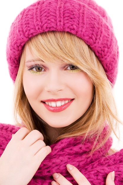 happy teenage girl in winter hat over white wall