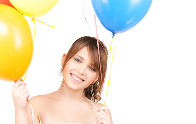 счастливая девочка-подросток с воздушными шарами над белой