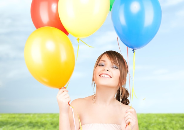 happy teenage girl with balloons over white