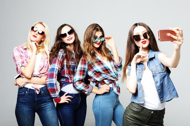 Happy teenage girls with smartphone taking selfie