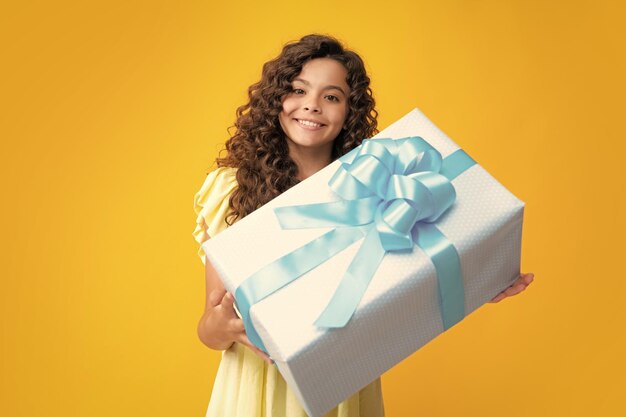 Happy teenager portrait child teen girl 1214 years old with\
gift on isolated background birthday holiday concept teenager hold\
present box smiling girl