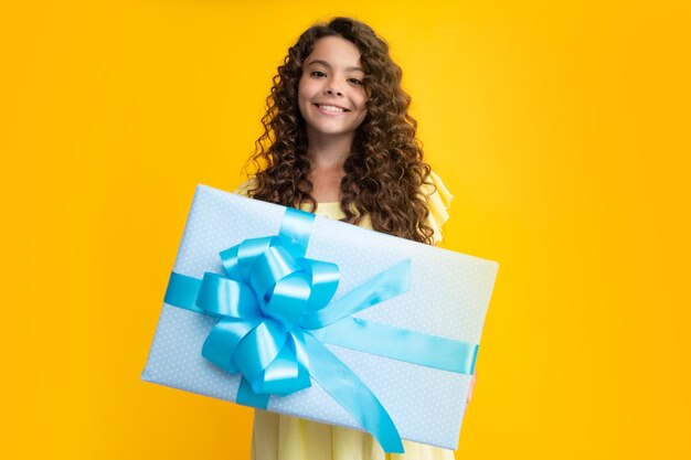 Happy teenager portrait child with gift present box on isolated\
background presents for birthday valentines day new year or\
christmas smiling girl