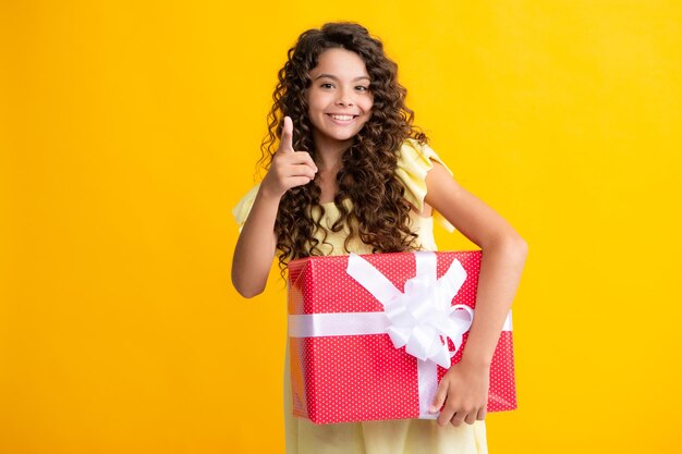 Happy teenager portrait Child with gift present box on isolated background Presents for birthday Valentines day New Year or Christmas Smiling girl