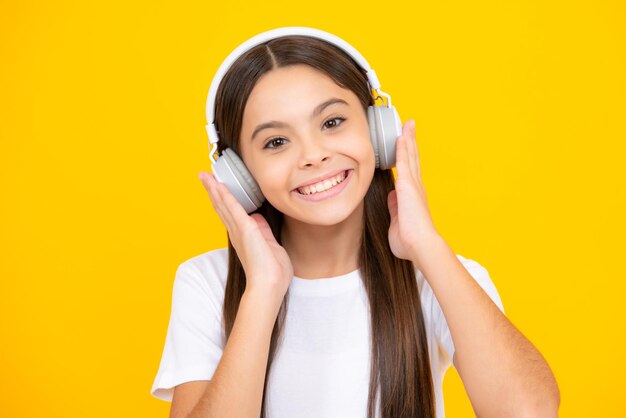 Happy teenager portrait funny kid girl 12 13 14 years old listen music with headphones teenage girl with headphones listening songs on headset earphone smiling girl