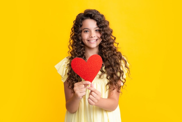 Happy teenager portrait Lovely child teen girl with shape heart love holiday and valentine symbol Valentine or birthday day Gift heart present Smiling girl