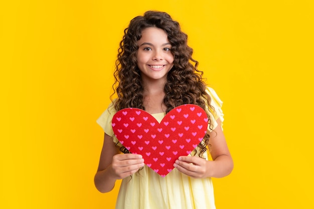 Happy teenager portrait Lovely child teen girl with shape heart love holiday and valentine symbol Valentine or birthday day Gift heart present Smiling girl