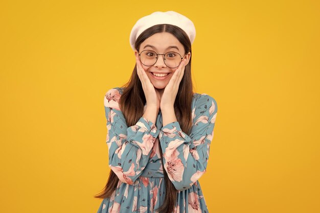 Happy teenager positive and smiling emotions Shocked teenager child portrait isolated on yellow background Surprised teenage girl