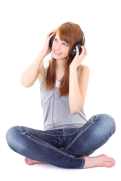 Happy teenager with headphones sitting over white