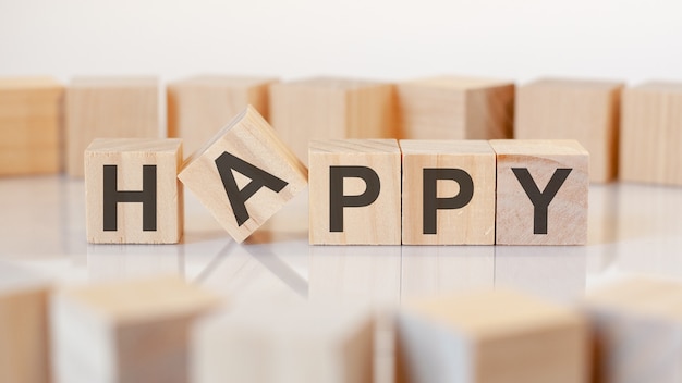 Happy text on a wooden blocks, gray background