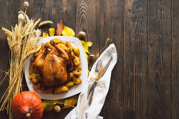 Happy Thanksgiving Autumn composition with leaves ripe pumpkin and Thanksgiving turkey on a dark wooden table Top view