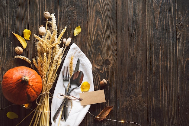 Happy Thanksgiving Autumn composition with leaves ripe pumpkin and Thanksgiving turkey on a dark wooden table Top view