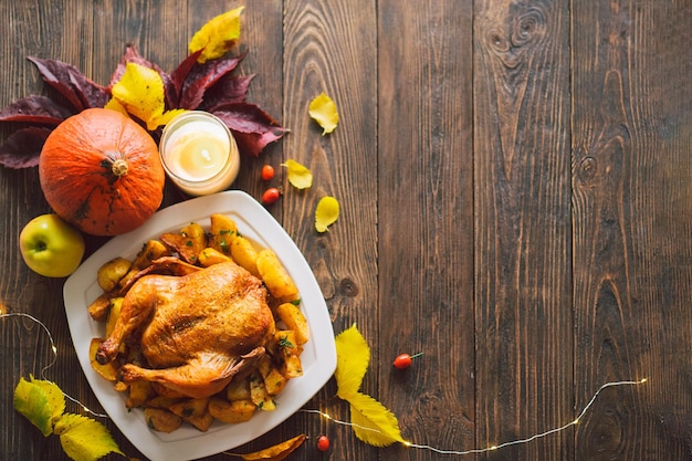 Happy Thanksgiving Autumn composition with leaves ripe pumpkin and Thanksgiving turkey on a dark wooden table Top view