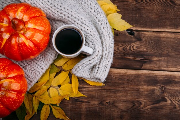 Happy thanksgiving concept met oranje pompoenen gele bladeren en kopje koffie op houten